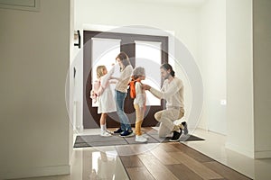 Parents get children ready for school walk standing at hallway