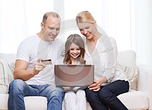 Parents and girl with laptop and credit card