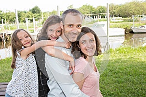 Parents Giving Children daughter girls piggybacks In Countryside