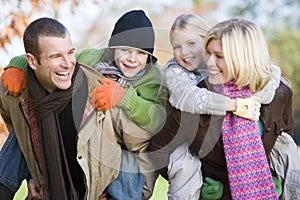 Parents giving children piggyback ride