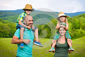 Parents giving piggyback ride to children, happy family