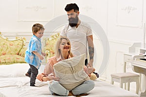 Parents with happy faces pay attention to kid, play. Happy family concept. Mother and father play with cute son. Young