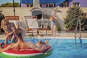 Parents having fun at the swimming pool with their children