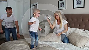 Parents having fun with their little daughter on bed. Family spending time at the morning