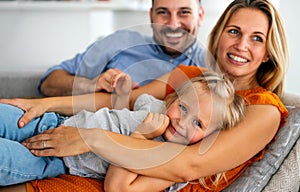 Parents having fun with their little daughter on bed. Family spending time at the morning.