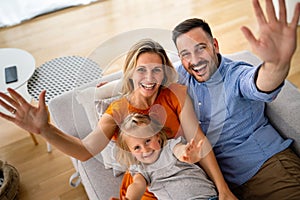 Parents having fun with their little daughter on bed. Family spending time at the morning.