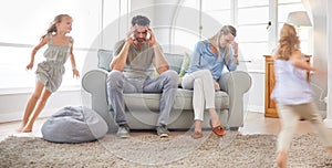 Parents headache, running children and family stress in home living room, anxiety from happy kids and burnout in lounge