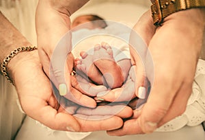 Parents holding baby feet in their hands