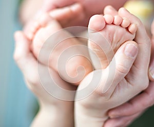 Parents holding feet of his newborn son