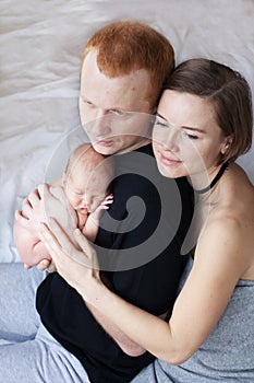 Parents hug their newborn baby.