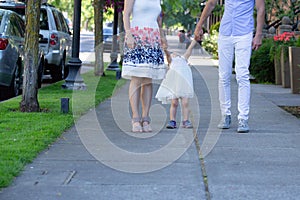 Parents, husband and wife, walk with their girl toddler