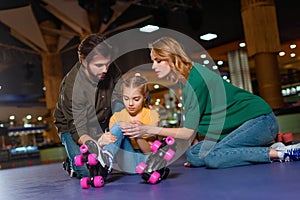parents and injured daughter in roller skates sitting