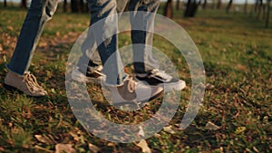 Parents kid leg walking autumn park field together closeup. Outdoor leisure time