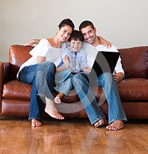 Parents and kid using a laptop with thumbs up