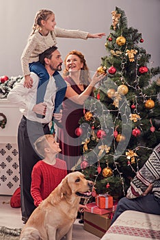 Parents and kids beautifying Christmas tree