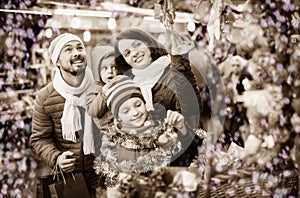 Parents with kids choosing X-mas decorations in market