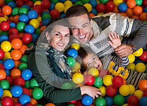 Parents and kids playing in the pool with colorful balls