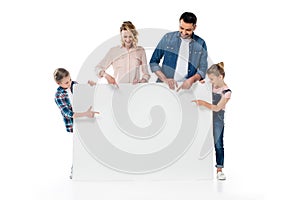 Parents and kids pointing at blank banner isolated on white