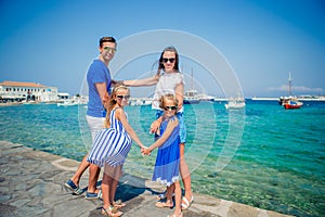 Parents and kids at street of typical greek traditional village on Mykonos Island, in Greece