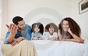 Parents, kids and watching tv on bed, together and relax with talking, choice or happy for movie in family home. Father