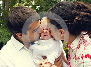 Parents kissing their crying baby