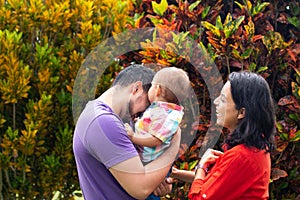 Parents laughing and hugging their child in autumn.Beautiful family three. Orange Rush concept