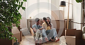 Parents little daughter tickling at living room at relocation day