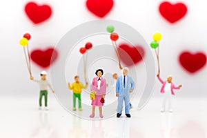 Parents love each other happily, with children playing balloons are behind, used as a wedding anniversary concept