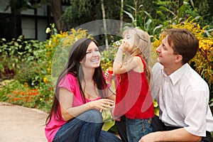 Parents observe as daughter blows soap bubbles