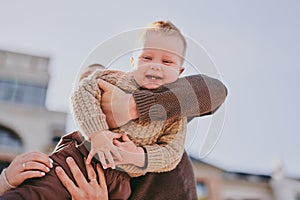 Parents play with their child close-up. Boy flying and laughing, happy family