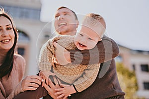 Parents play with their child close-up. Boy flying and laughing, happy family