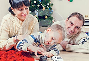 Parents playing with his son with Santa's gifts