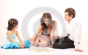 Parents playing mikado with their little daughter