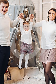 Parents playing with their daughter. Christmas decorations.