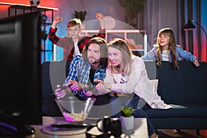 Parents playing video games while kids cheering them