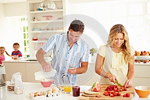 Parents Preparing Family Breakfast In Kitchen