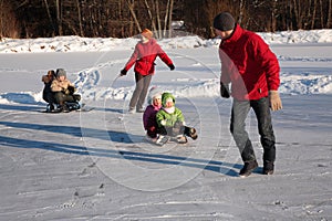 Parents pull children on sleds