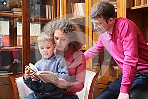Parents read book with son