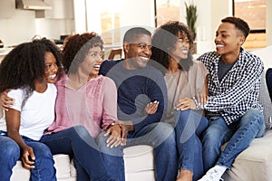 Parents relaxing at home with their teen and young adult kids photo