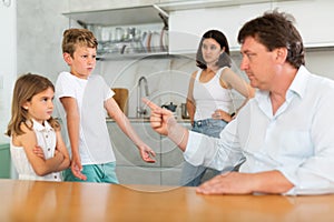 Parents scold their children in kitchen at home