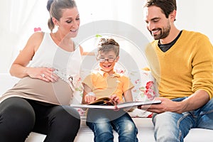 Parents showing their firstborn son pictures in family album