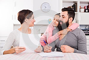 Parents signing property papers