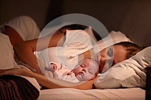 Parents Sleeping In Bed With Newborn Baby