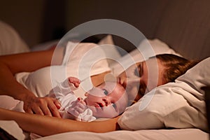 Parents Sleeping In Bed With Newborn Baby