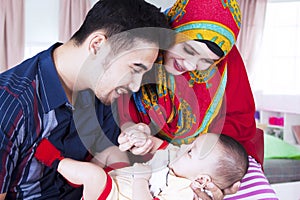 Parents smiling with baby in living room