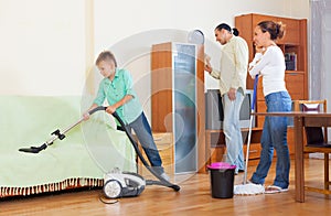 Parents with son doing house cleaning in home