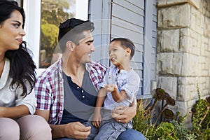 Parents With Son Sitting On Steps Outside Home