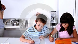 Parents standing next to children doing their homework