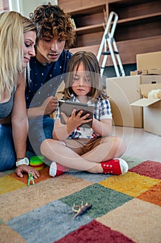 Parents supervising their little son playing tablet