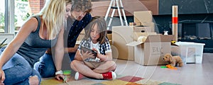 Parents supervising their little son playing tablet